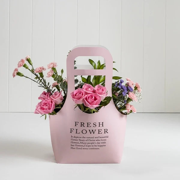 pink revival roses with blue daisy in pink paper box front view