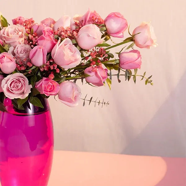 pink roses in a pink glass vase closeup view 2