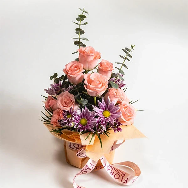 baby pink roses with chrysanthemums in a square glass vase close up view