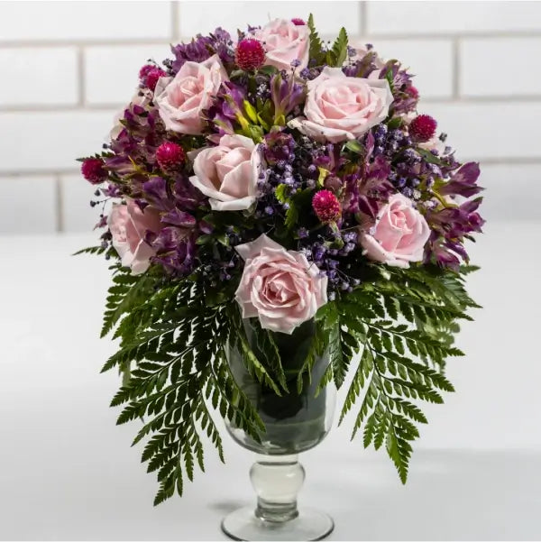 pink roses with purple alstroemeria in a glass vase front view