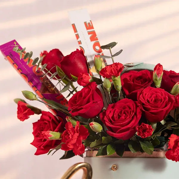 red roses flowers and chocolate in a light blue box close up view