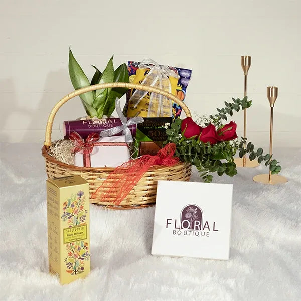 woven basket hamper with fresh flowers chocolates and assorted snacks front view