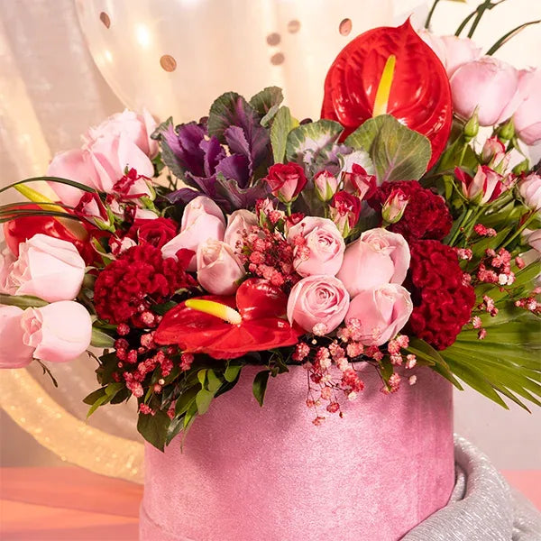pink box with balloons red and baby roses celosia close up view