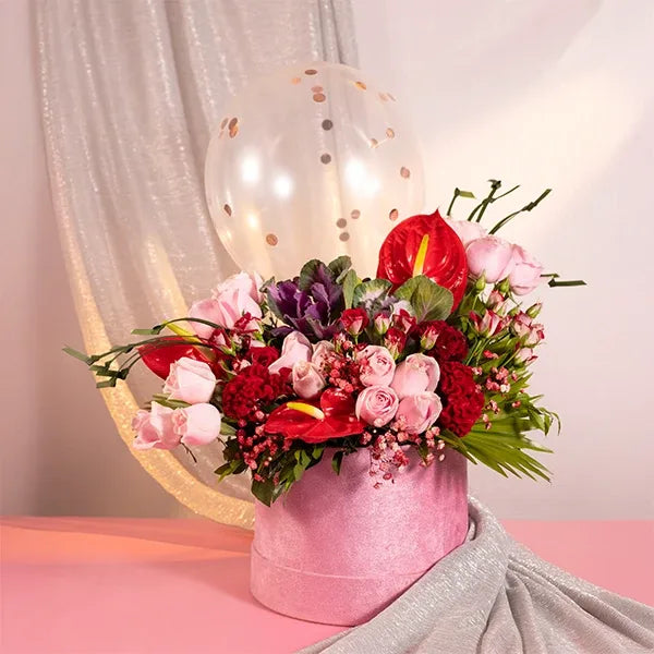 pink box with balloons red and baby roses celosia front view