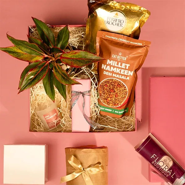 gift hamper of aglaonema pink diamond plant with eat better snacks and Perfume front view