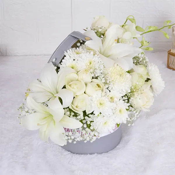white roses asiatic lilies orchids in grey gift box top view